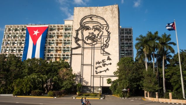CUBA – TWO PEOPLE PASS IN FRONT OF THE MINISTRY OF THE INTERIOR