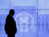 A guard walks in front of a Federal Reserve image before press conference in Washington